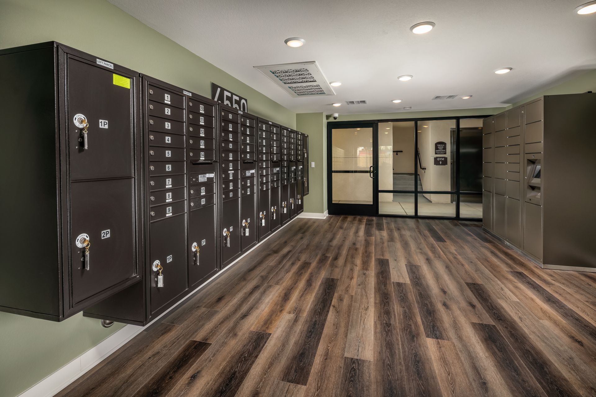 A room with a lot of lockers and a wooden floor.