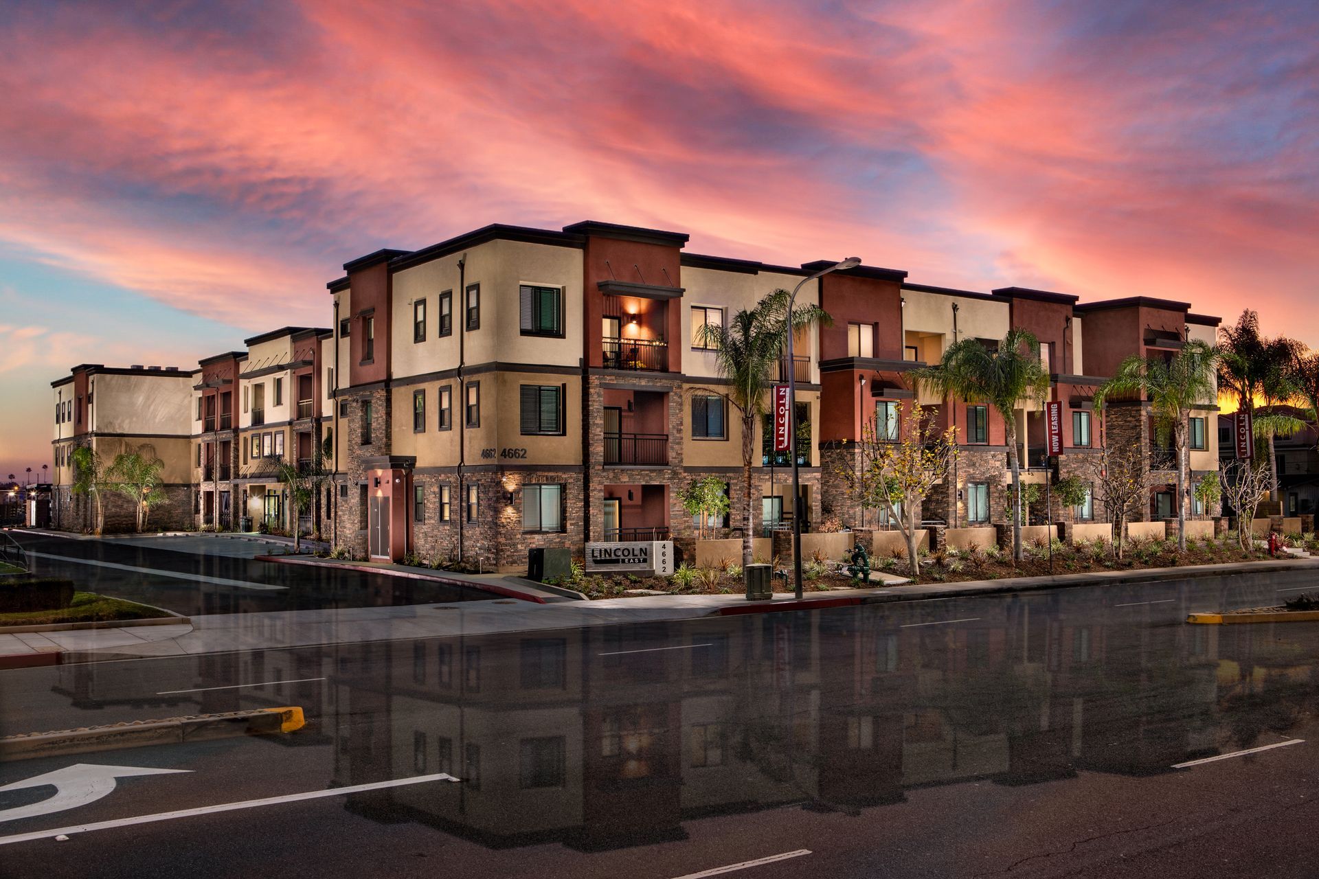 A large apartment building with a sunset in the background