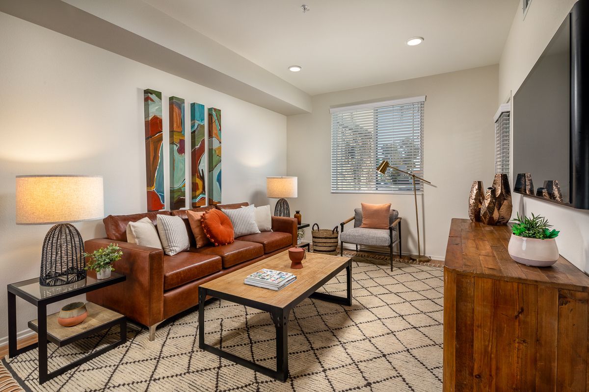 A living room with a couch , coffee table , chair and television.
