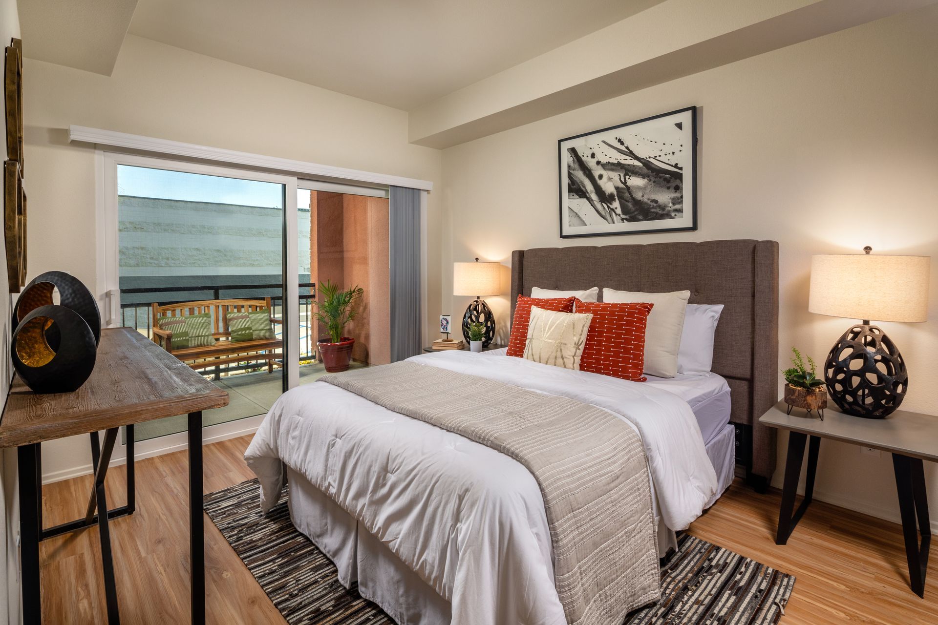 A bedroom with a king size bed and a sliding glass door leading to a balcony.