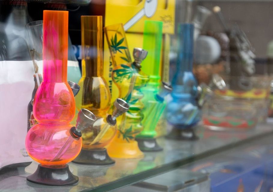 A glass bong with a light inside of it is surrounded by blue smoke.