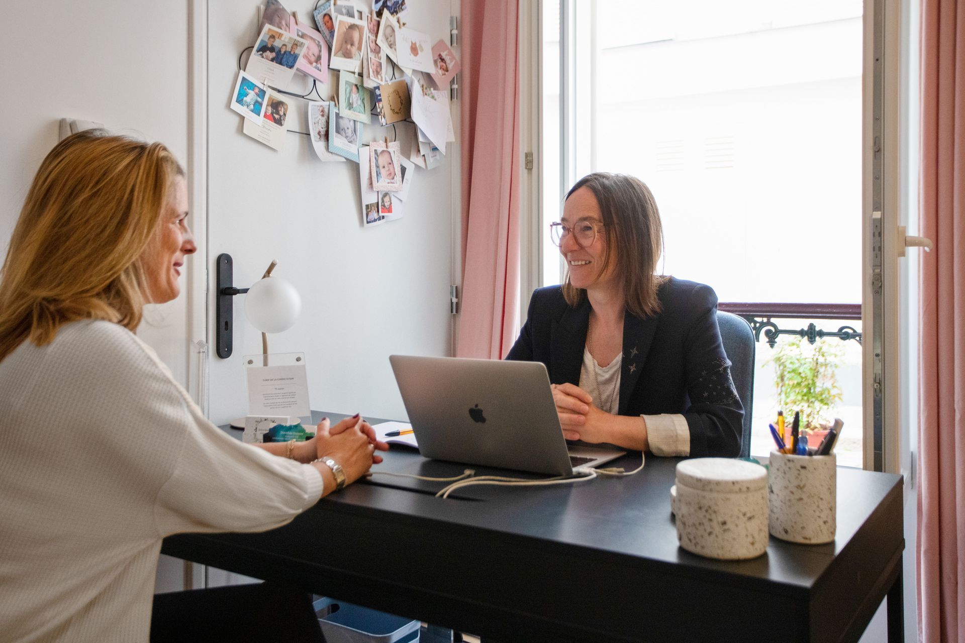 Deux personnes sont assises de part et d'autre d'un bureau dans un bureau lumineux