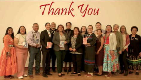 A group of people are standing in front of a thank you sign.