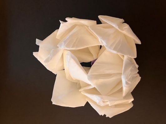Abstract white folded paper sculpture on a dark background