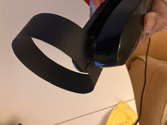 Person holding a black virtual reality headset with a ring-shaped strap.