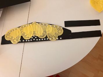 Yellow lace headband with black ribbon on a white table