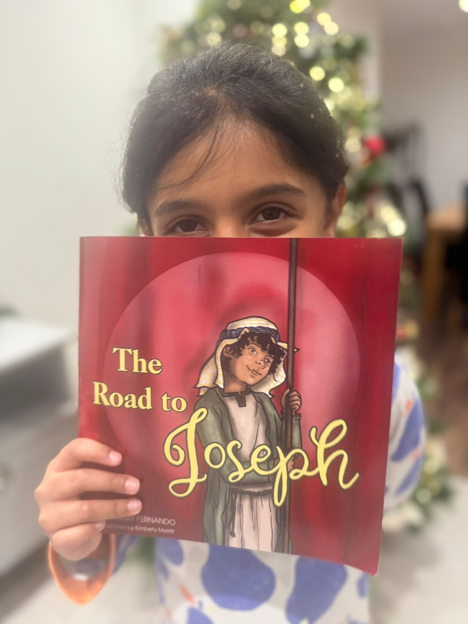 Child holding a book titled 