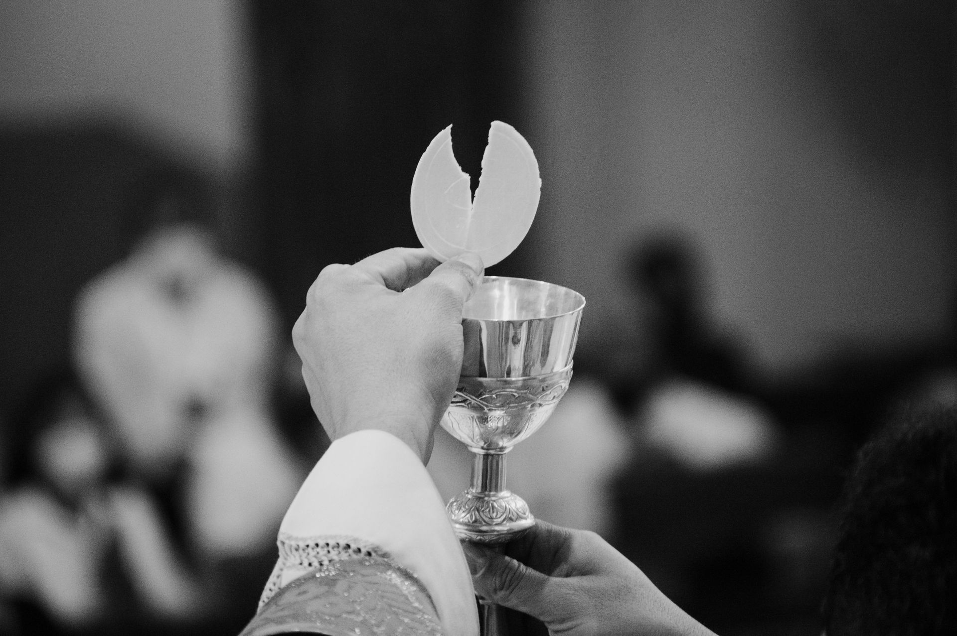 A person is holding a chalice with the Eucharist.