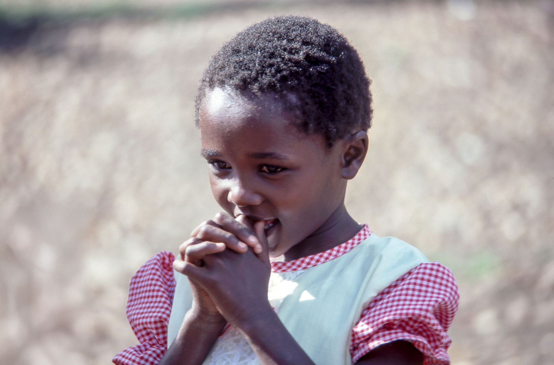 A little girl is praying with her hands together