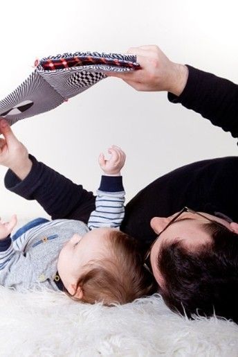 A man and a baby are laying on a blanket