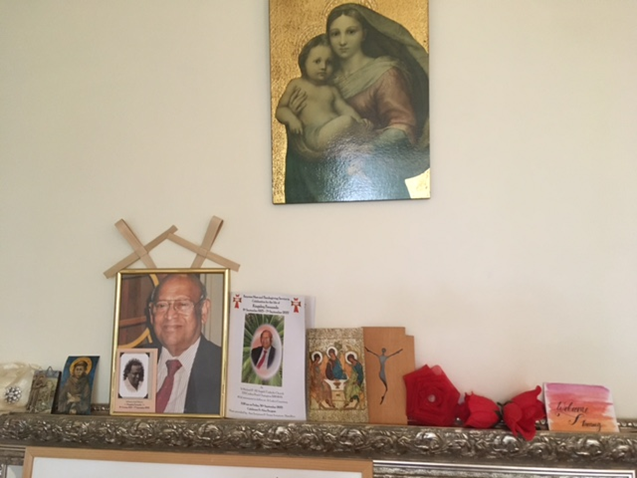 A altar with a picture of a man and a picture of the virgin Mary holding baby Jesus.