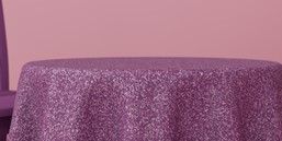 A round table with a purple tablecloth and a chair.
