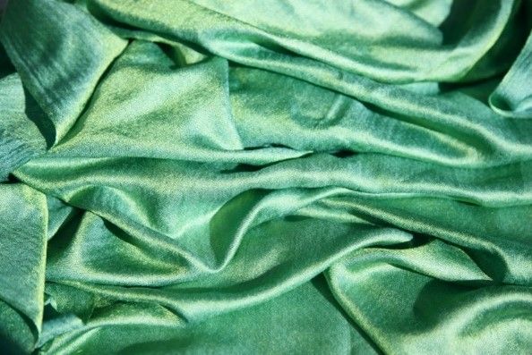 A close up of a green satin fabric.