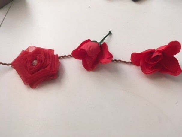 A string of red roses on a white surface