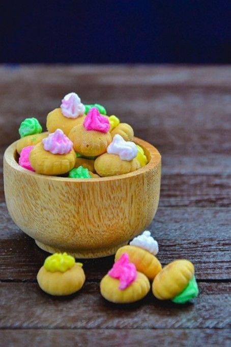 A wooden bowl filled with candy on a wooden table.