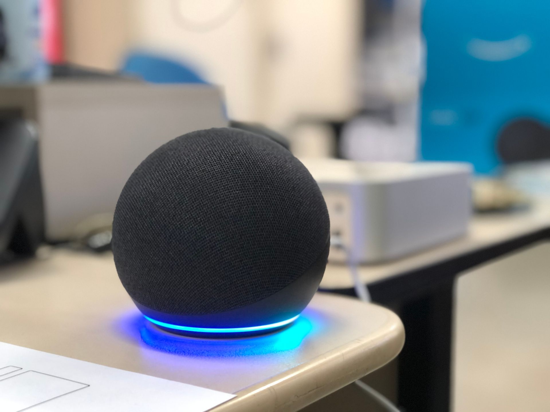 A small black speaker is sitting on a desk.