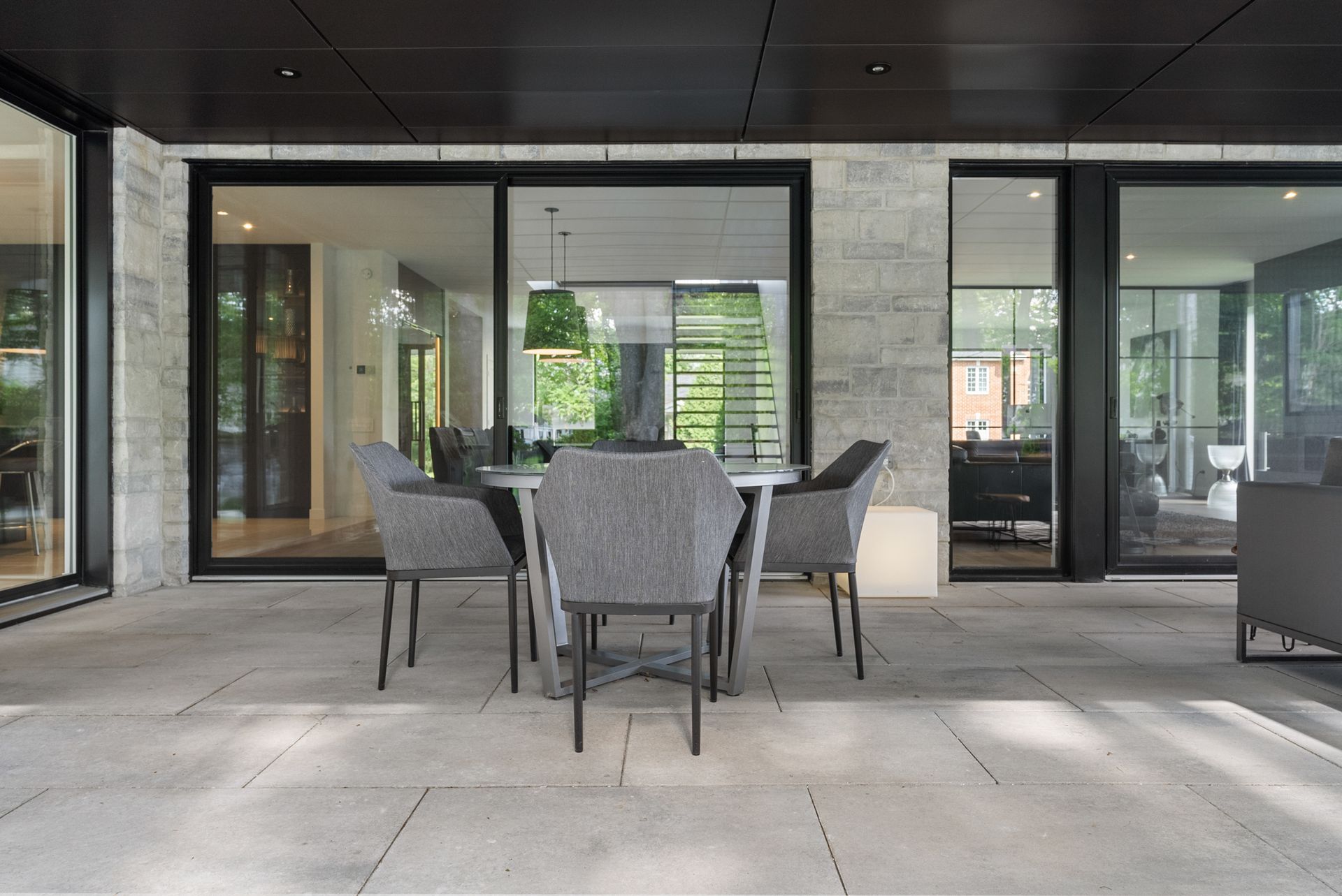 Il y a une table et des chaises sur le patio d'une maison.