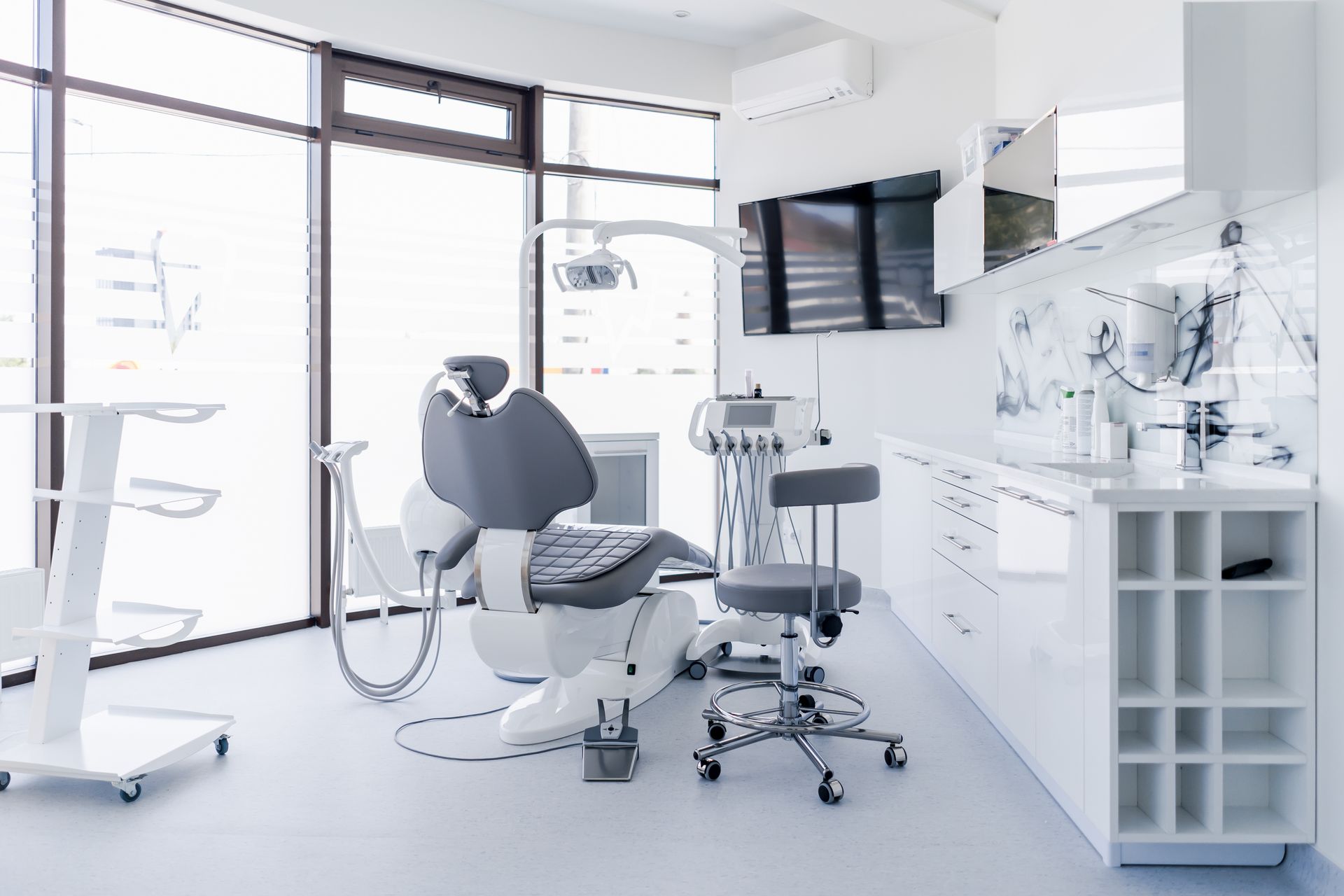 Interior of a dental clinic showing a chair, sink, and dental instruments for patient examinations