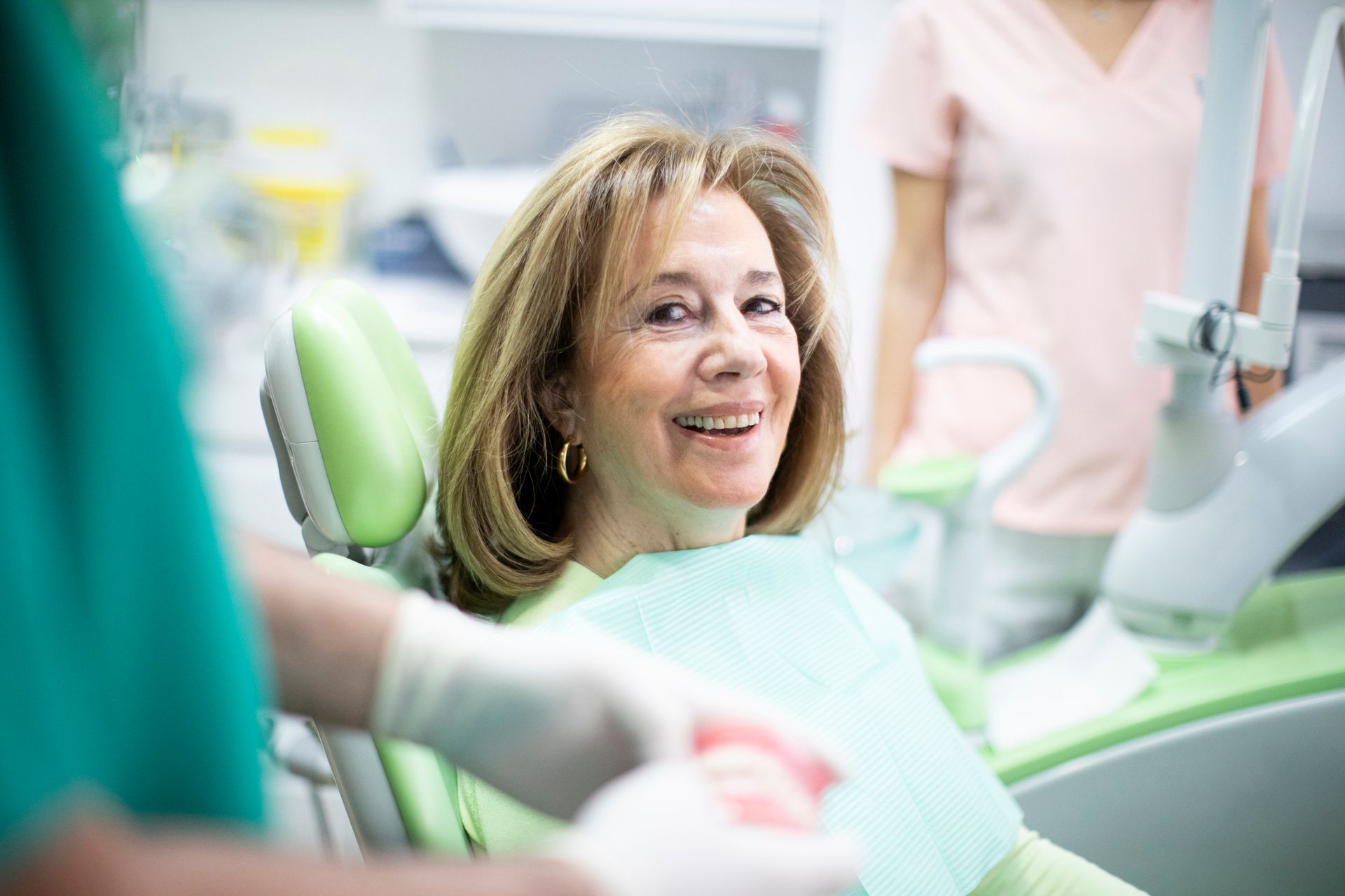Patient seated in a dental chair during a checkup at a modern dental clinic.