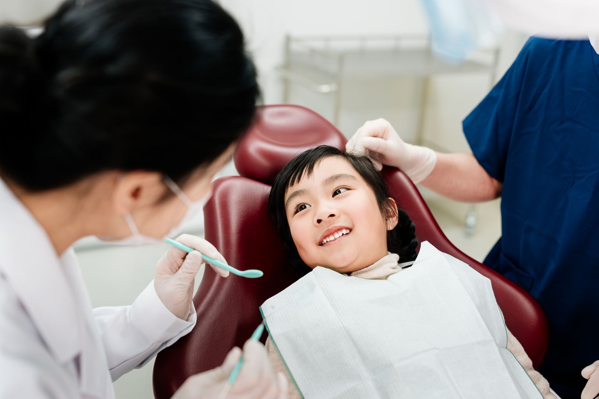 Asian little girl smiling during a pediatric airway dentist appointment in modern dental clinic. Asian little girl smiling during a pediatric airway dentist appointment in modern dental clinic.