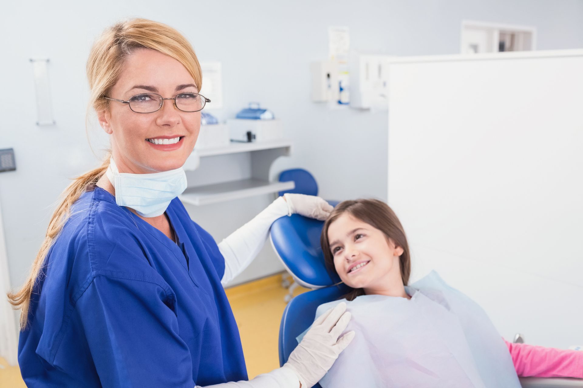 A smiling pediatric dentist with a happy young patient at Sacrey Dentistry & Associates dental office in Geneva, IL