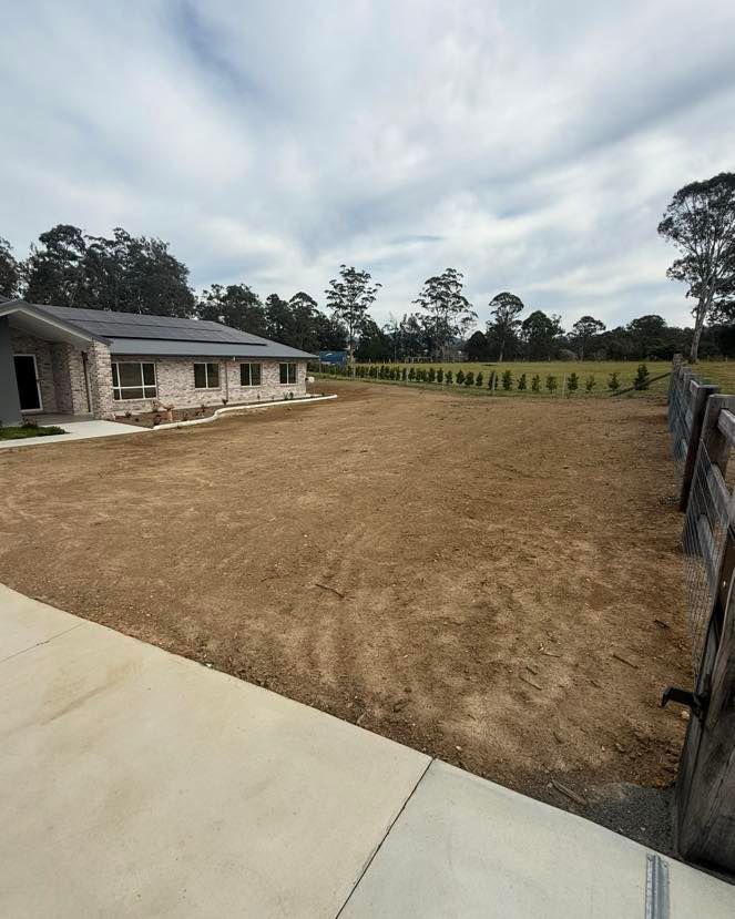 A Single-Story House with A Bare Yard and Concrete Driveway, Under a Cloudy Sky — East Coast Hydroseeding in Forster, NSW