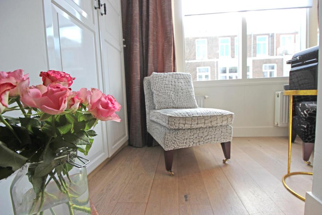 Ein Zimmer mit einem Stuhl und einer Vase mit Blumen