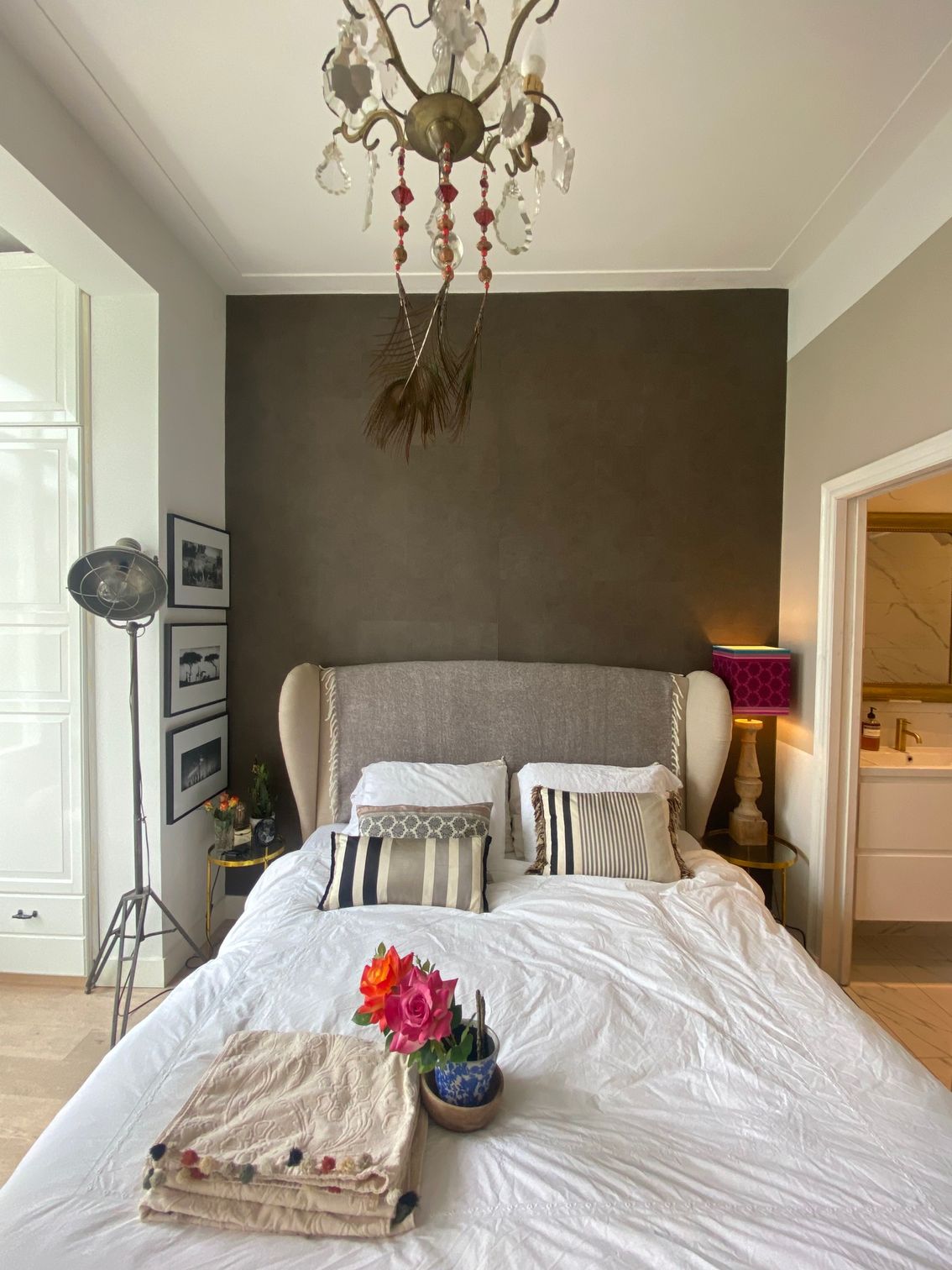 Ein Schlafzimmer mit einem Bett und einem Kronleuchter, der von der Decke hängt