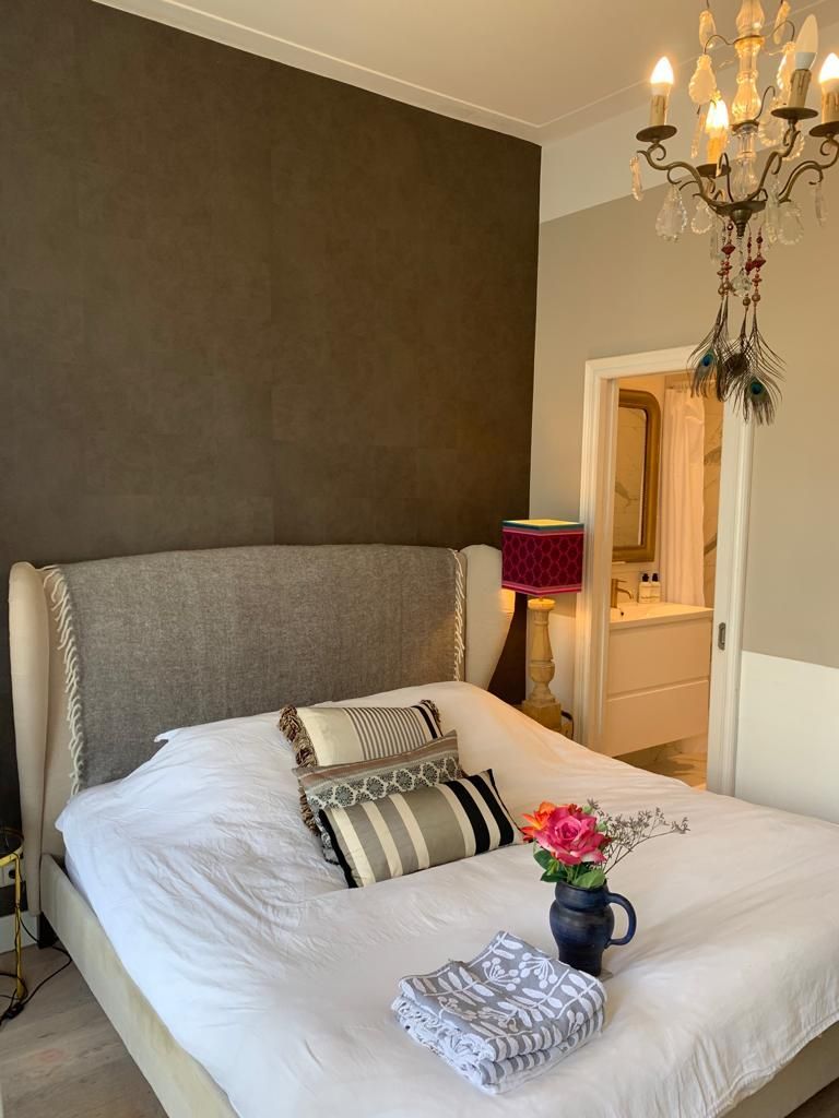 Ein Schlafzimmer mit einem großen Bett und einem Kronleuchter