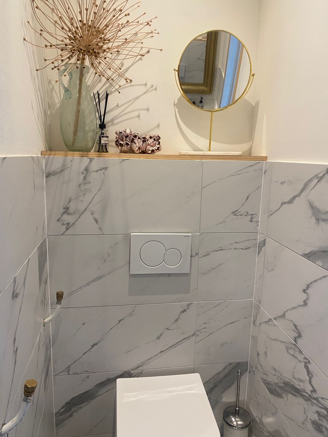 Ein Badezimmer mit Toilette und Spiegel an der Wand