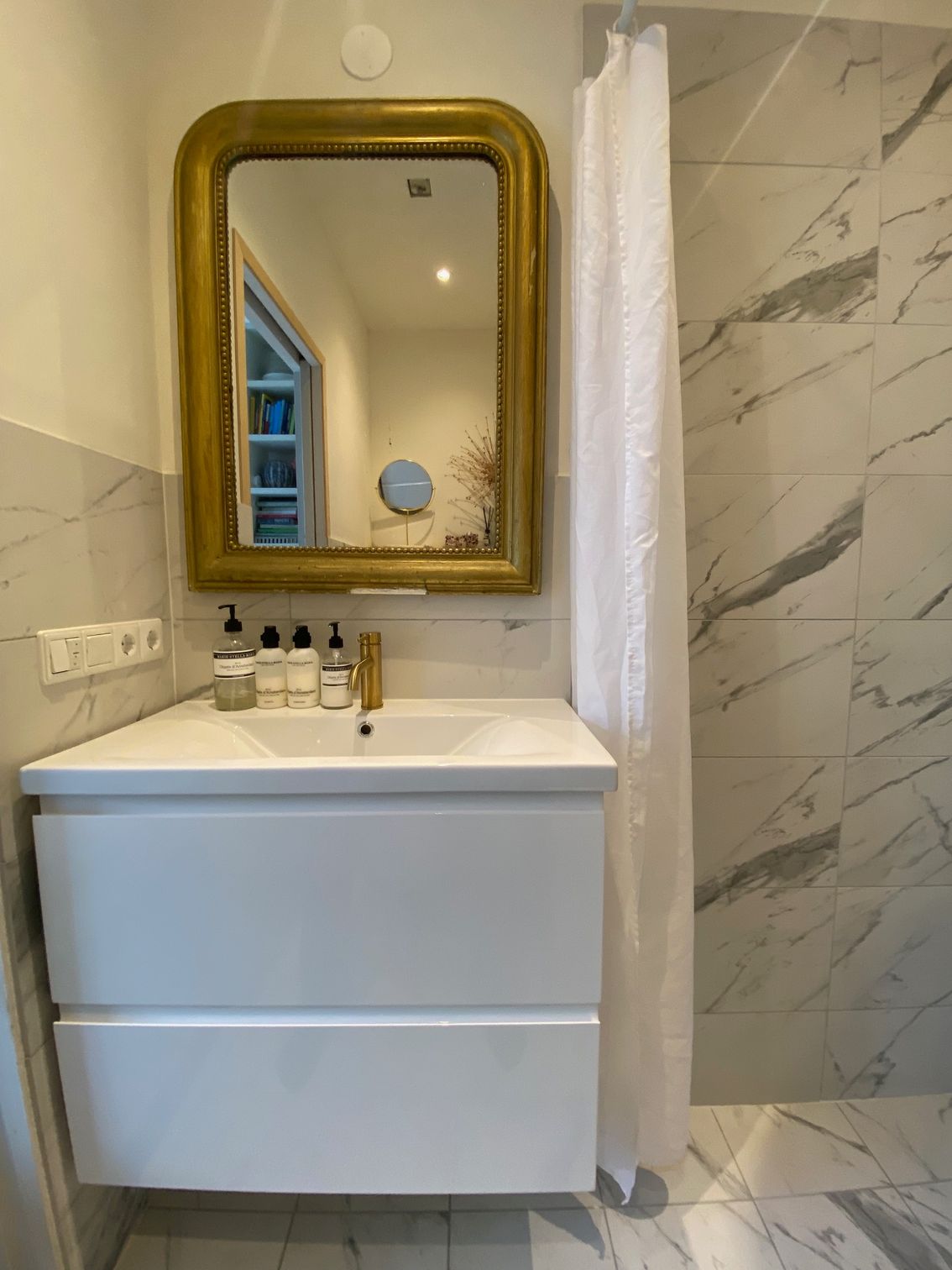 Ein Badezimmer mit Waschbecken, Spiegel und Duschvorhang