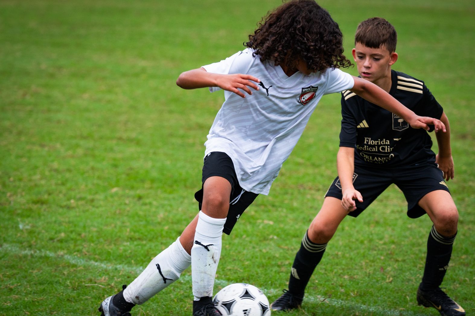 Space Coast United Soccer soccer team in a huddle with coaches