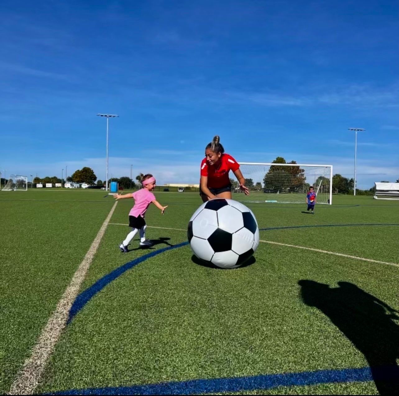 Woman and child playing soccer in Space Coast United Soccer Tiny Toes program