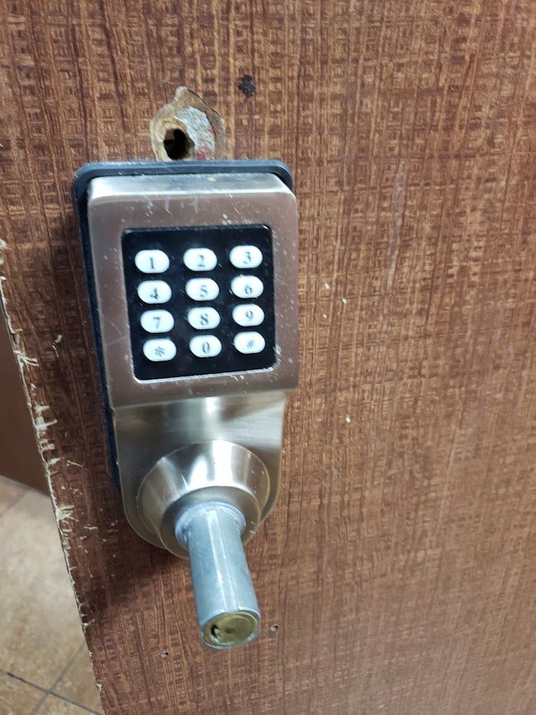 A close up of a digital door lock on a wooden door.