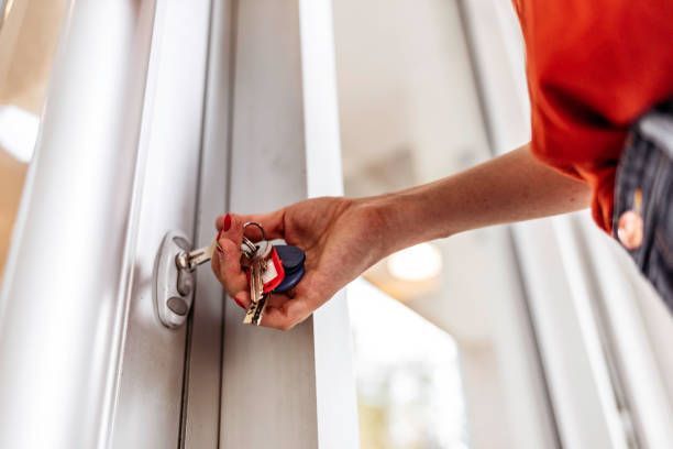 A person is opening a door with a key.