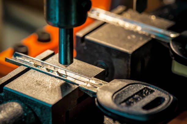 A close up of a key being cut in a machine.