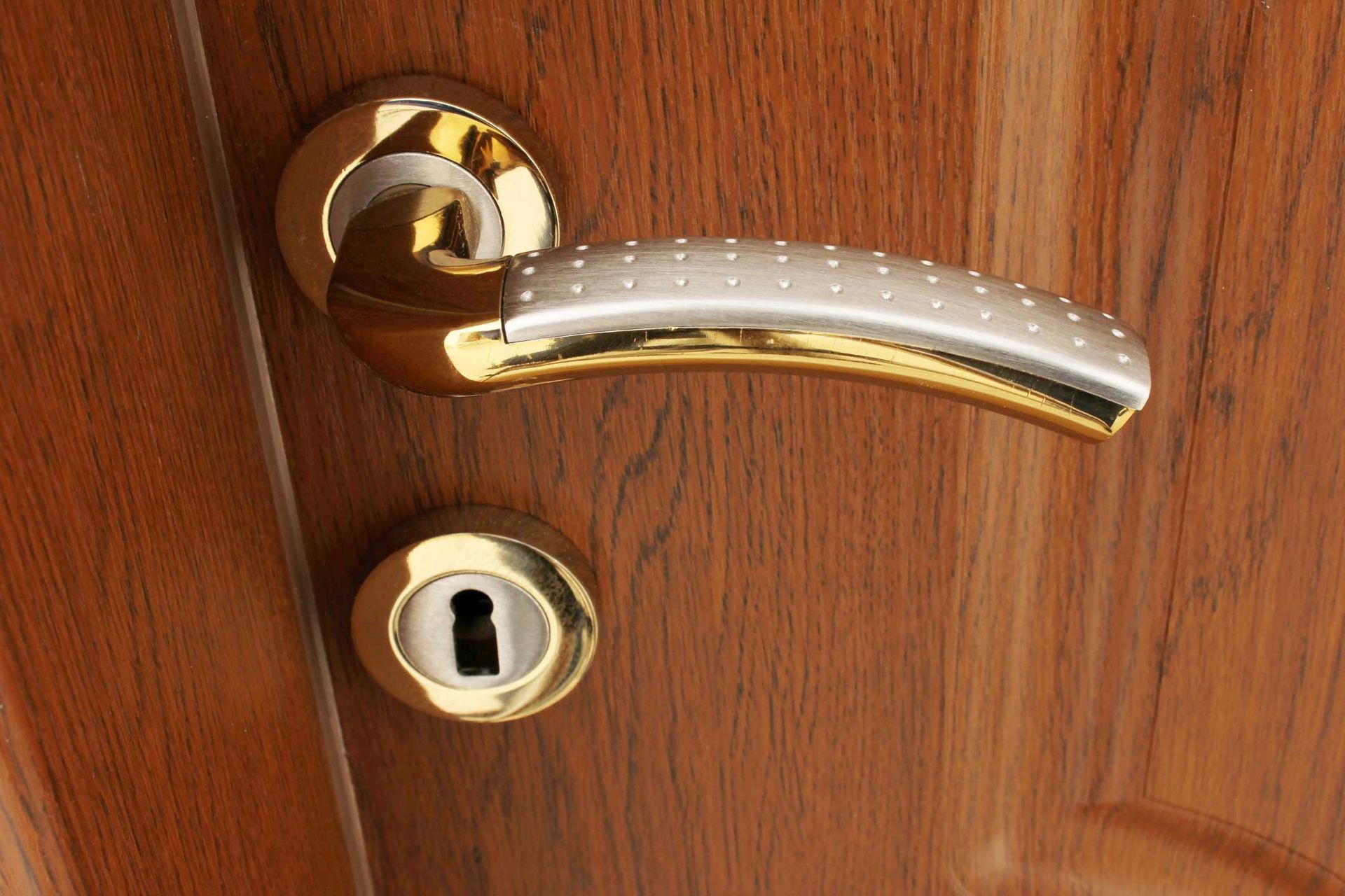 A close up of a door handle on a wooden door