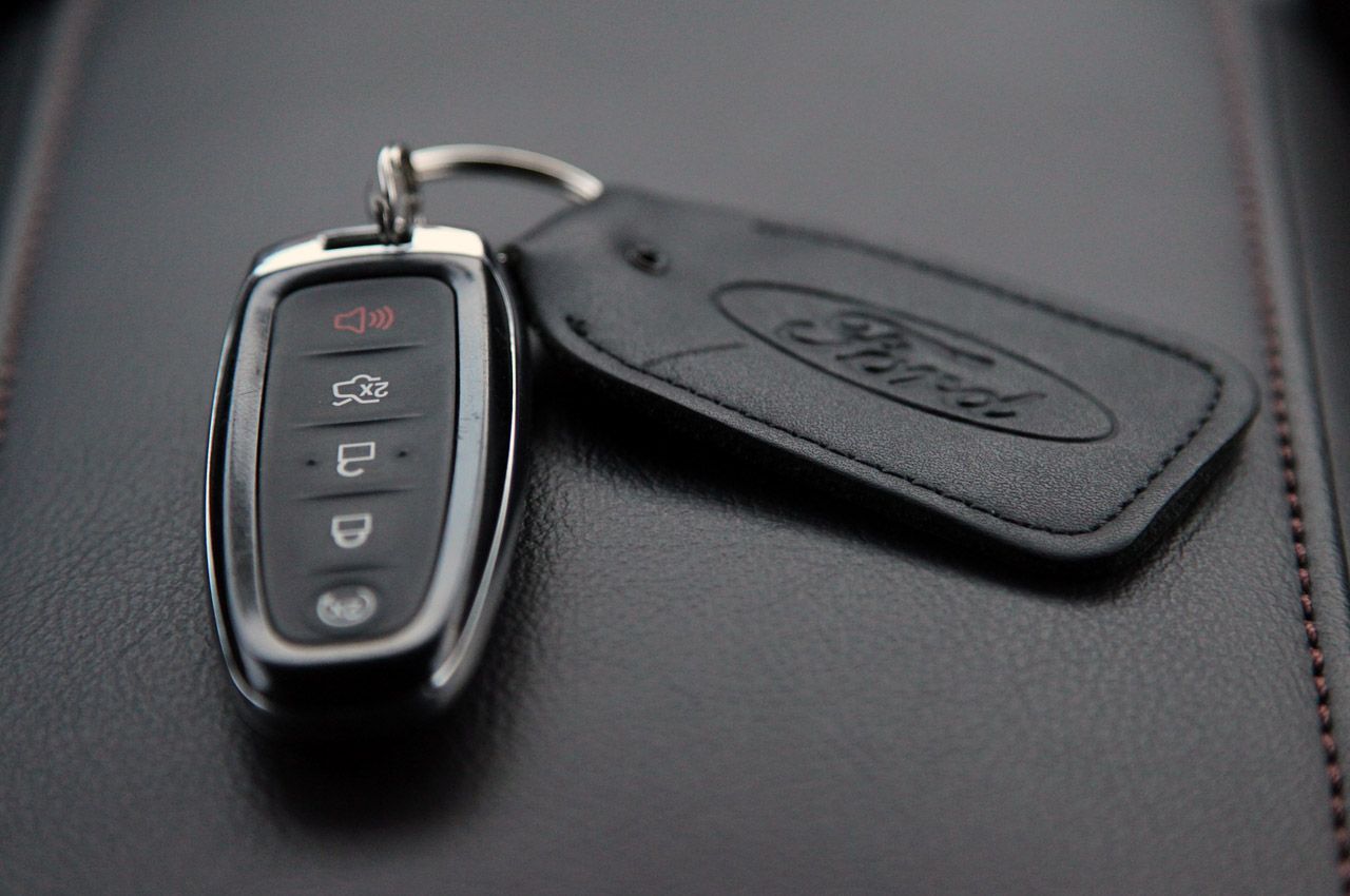 A close up of a ford remote control on a black surface.
