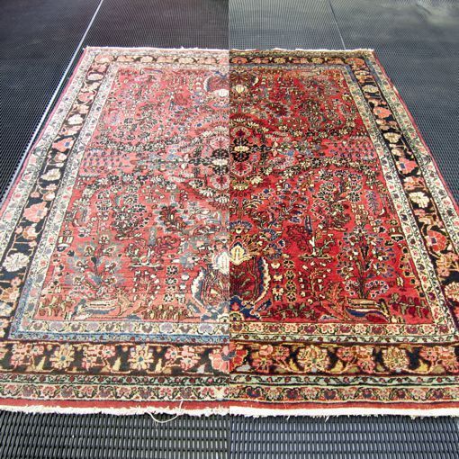 A detailed oriental rug lies on a dark floor.