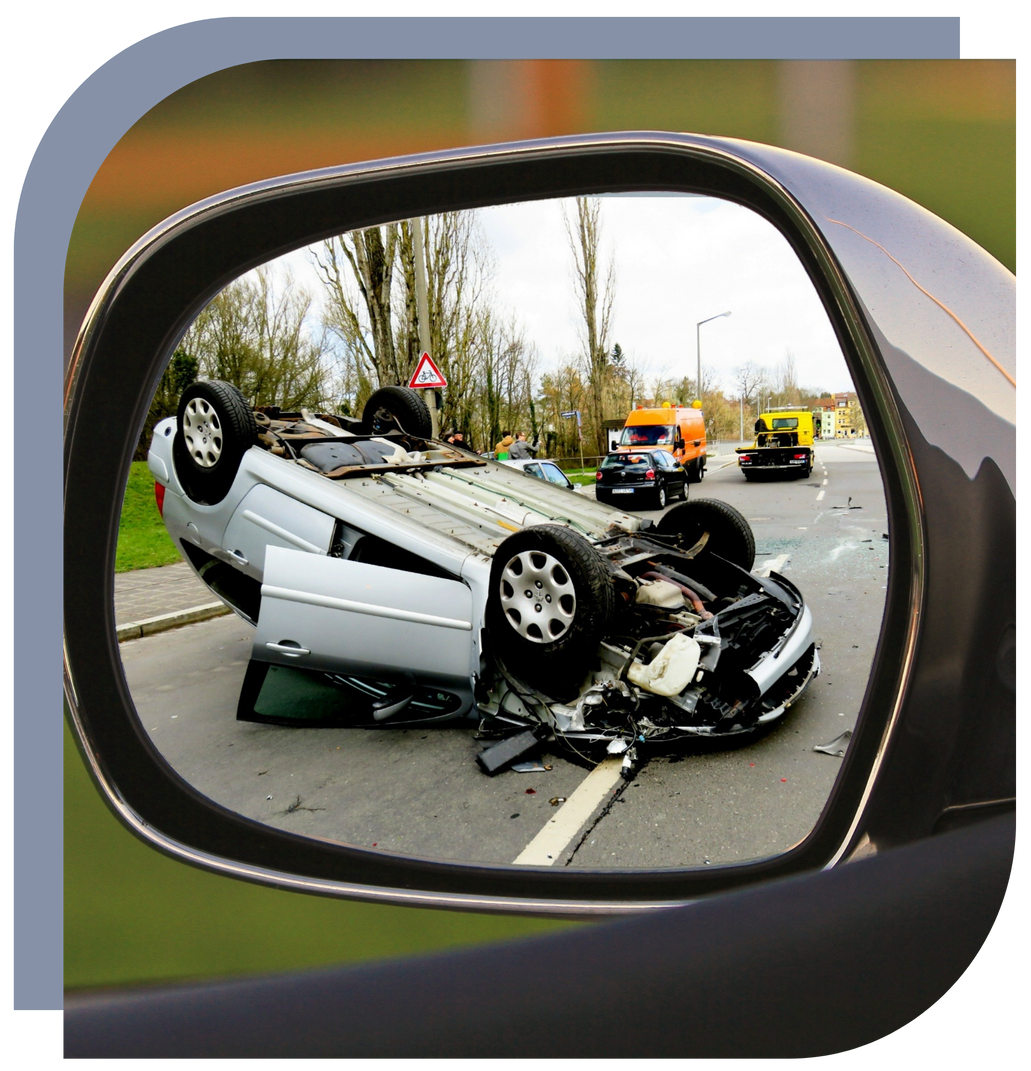 A rear view mirror shows a car on its side