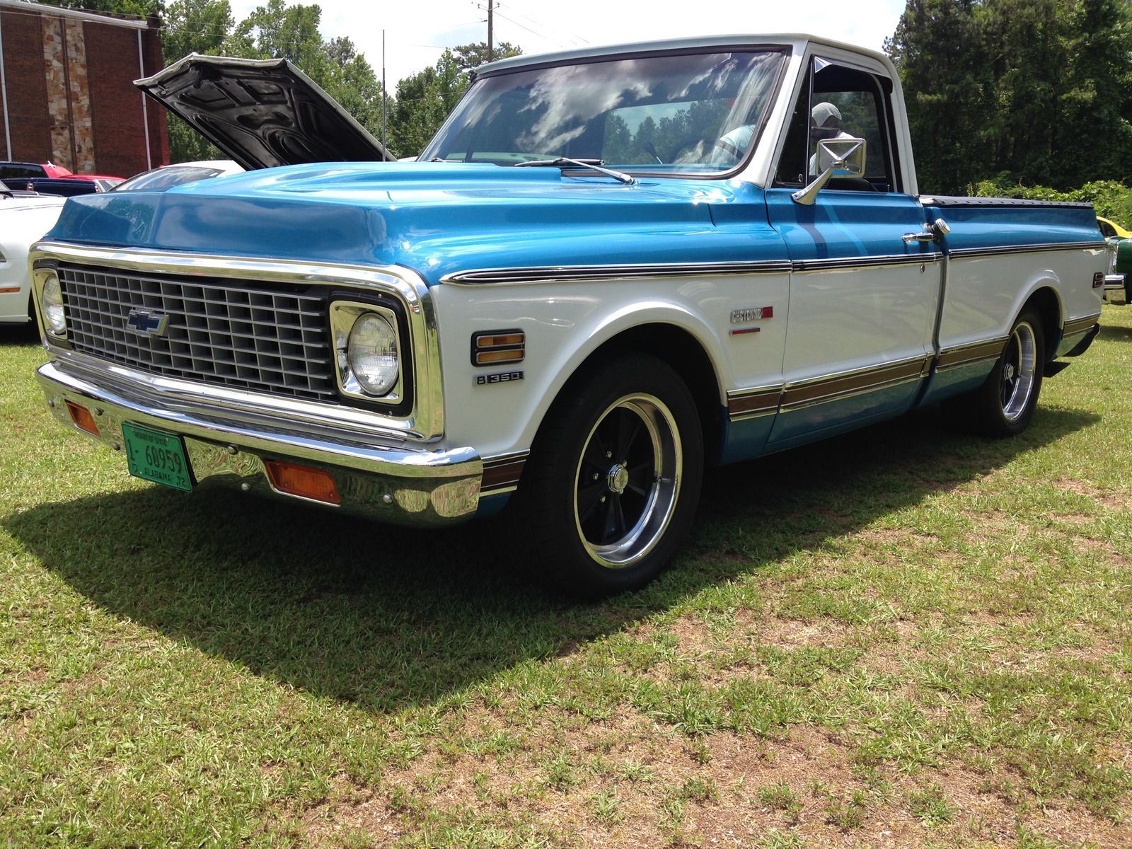 Classic blue and white Chevrolet pickup truck on grass, parked outdoors.