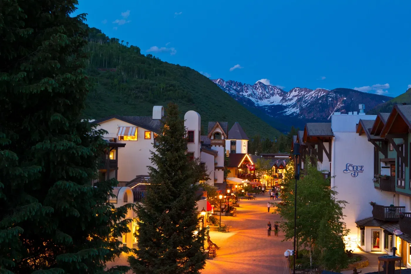 A city street with mountains in the background at night