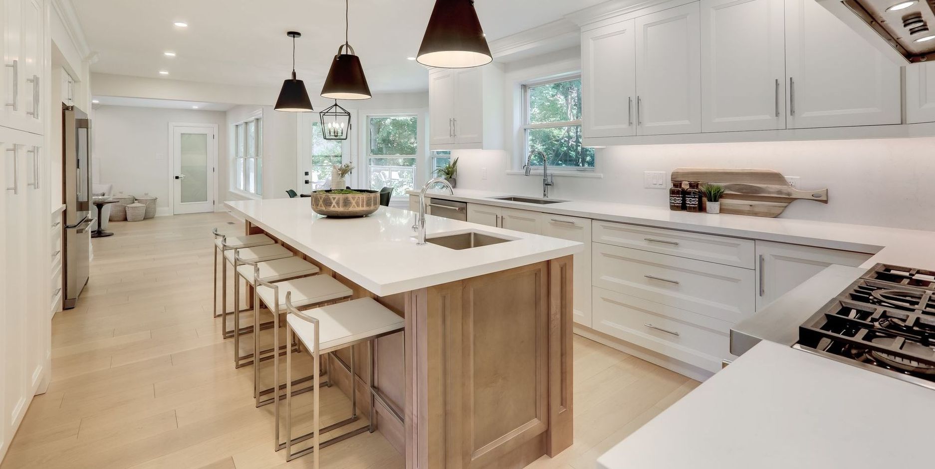 A kitchen with white cabinets and stainless steel appliances and a large island.