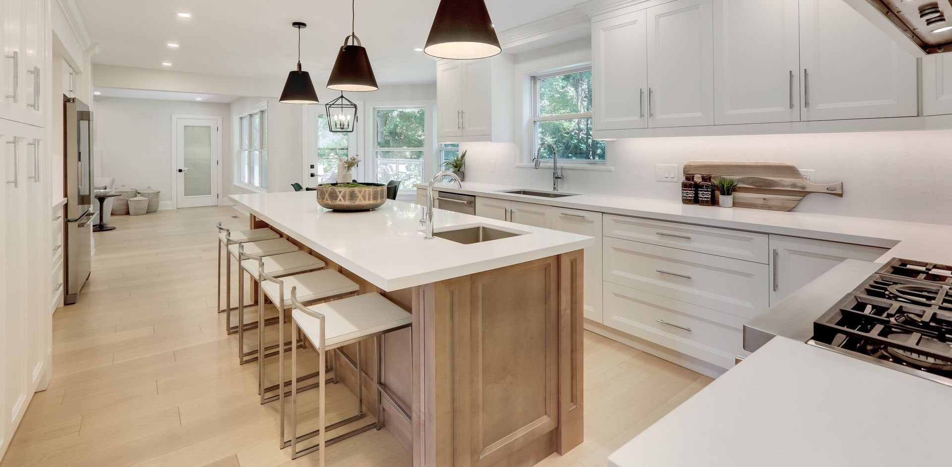 A kitchen with white cabinets and a large island in the middle.