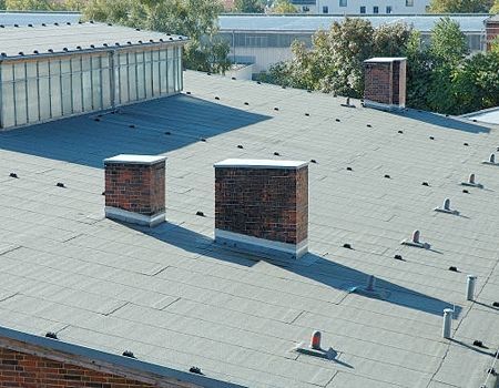 A stone fireplace with a white mantle in a living room.