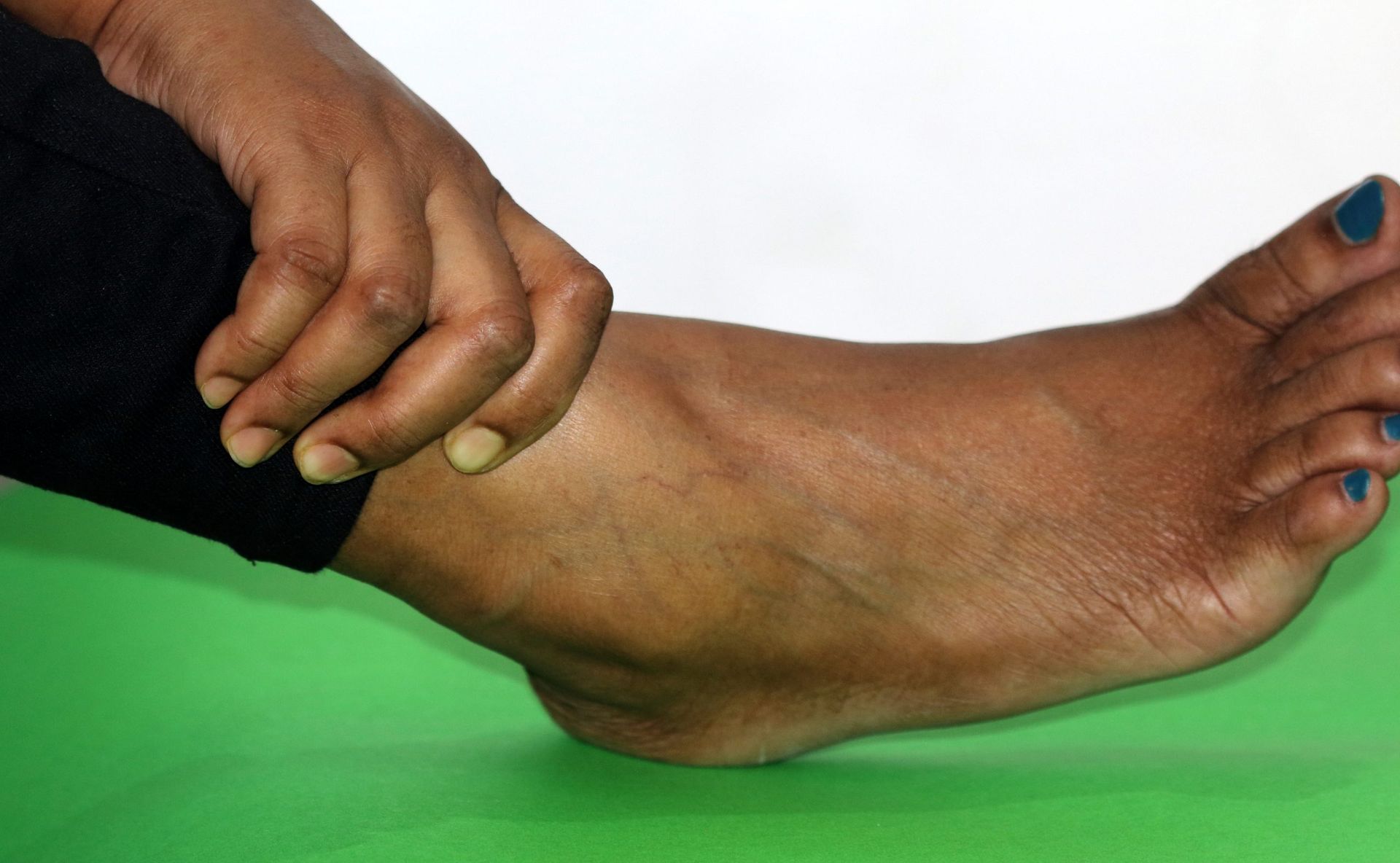 A close up of a person 's foot on a green mat.