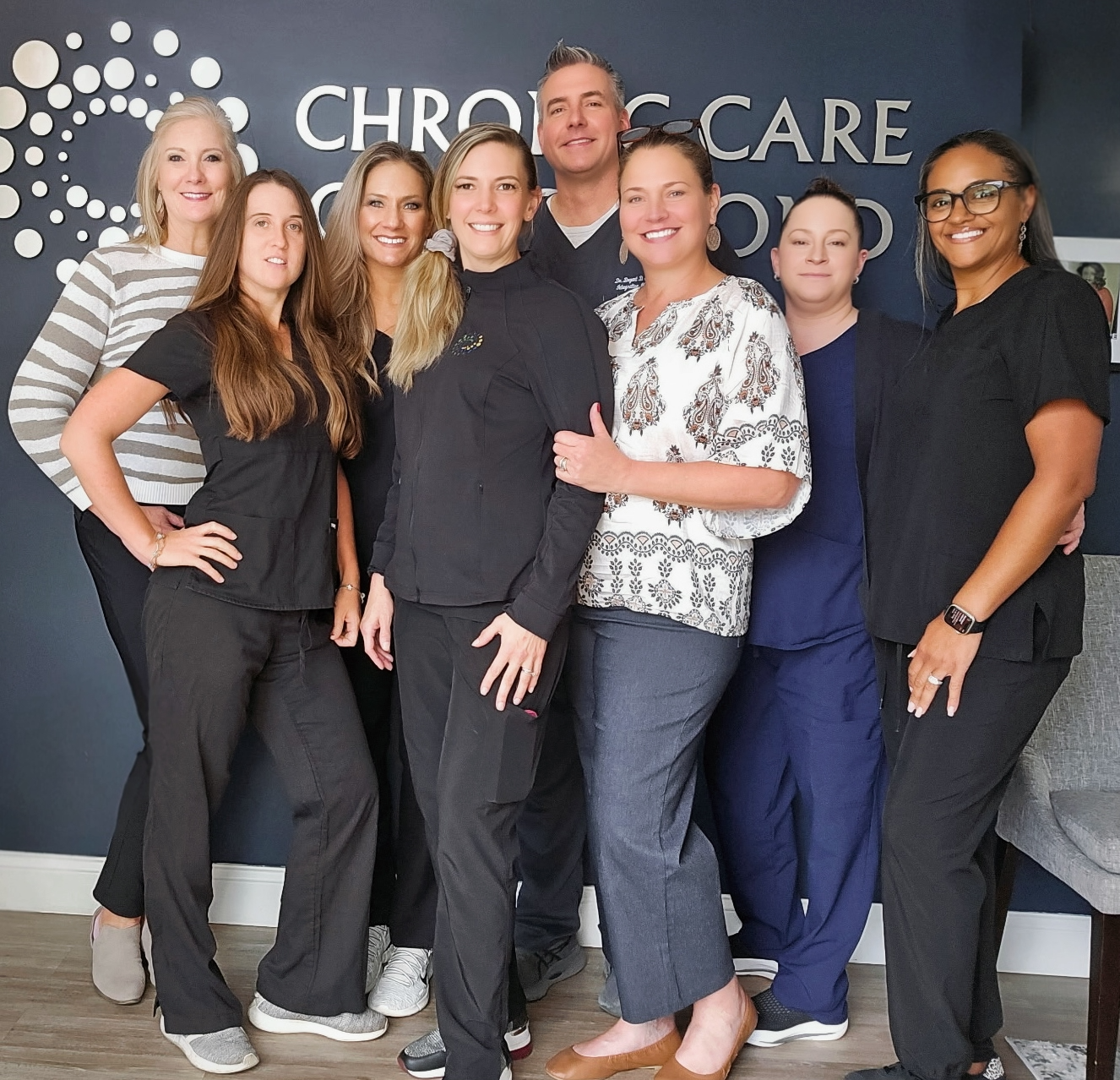 A group of people standing in front of a sign that says chronic care