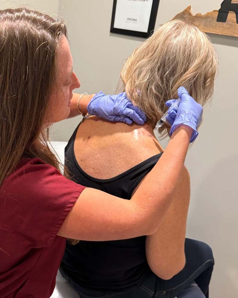 Patient receiving trigger point injections in shoulder knots from nurse practitioner