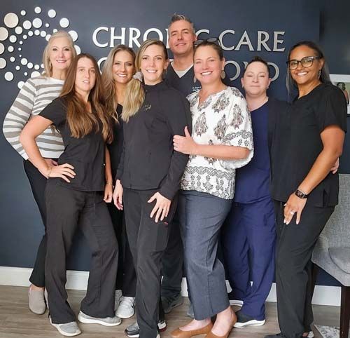 A group of people standing in front of a sign that says chronic care