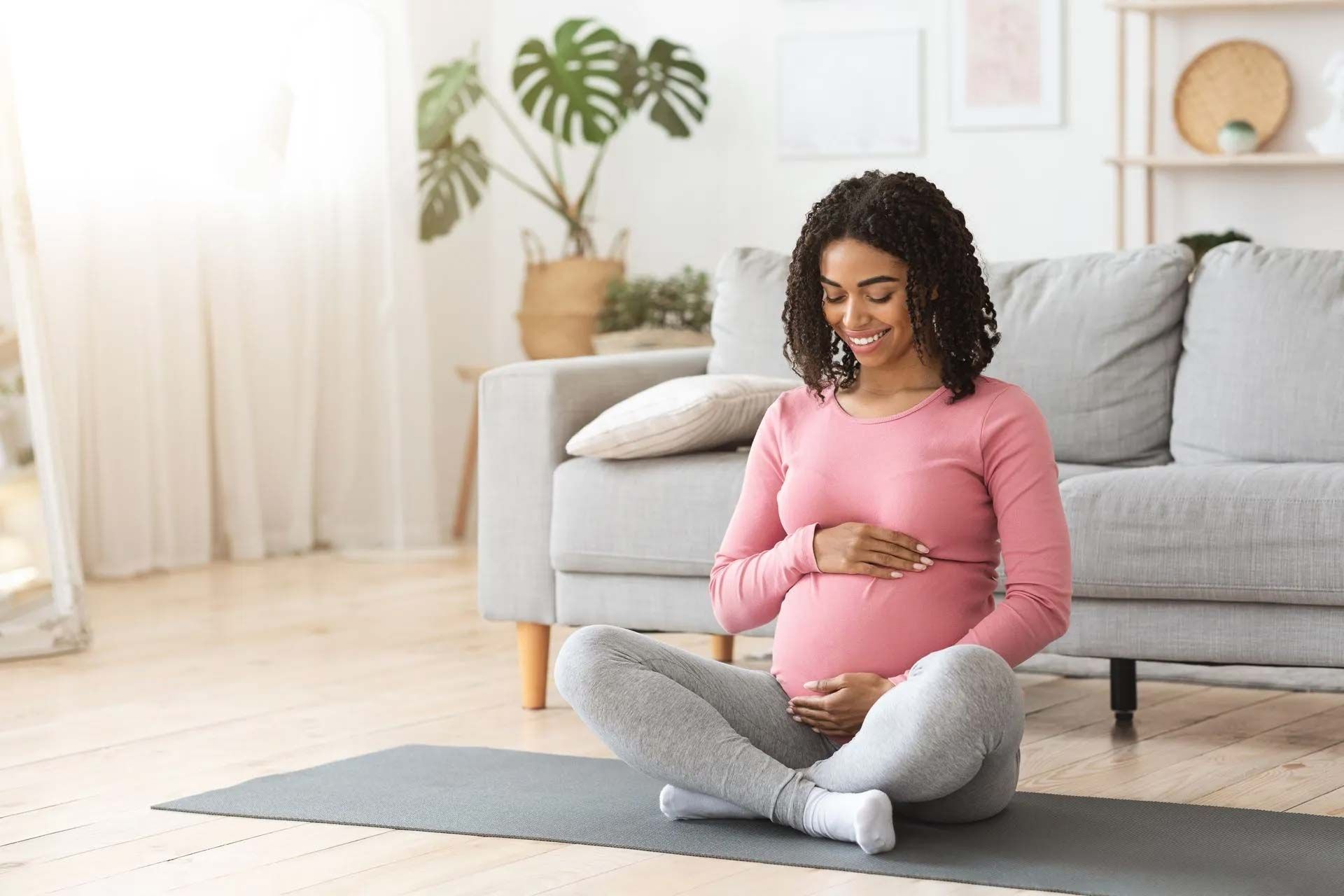 xpectant mother practicing prenatal mindfulness on a yoga mat in a serene home setting.